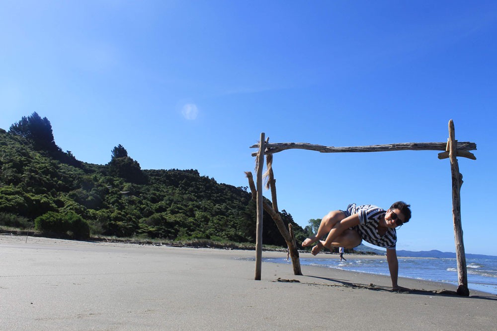 una chica saltando en la arena de una playa